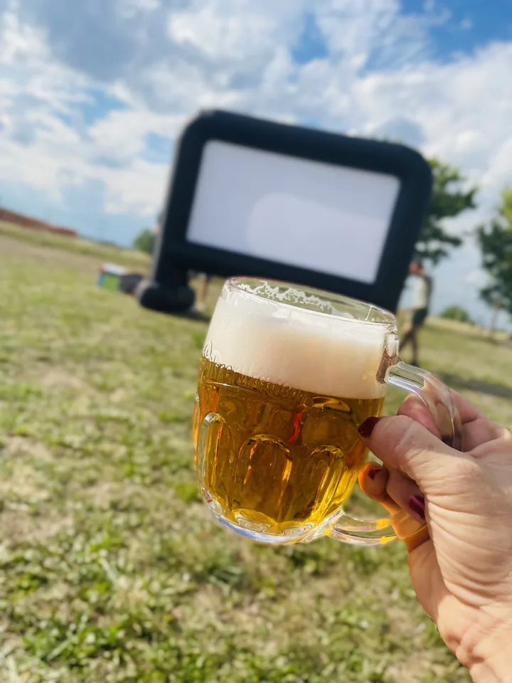 Sklenice piva a promítací plátno na zahradě